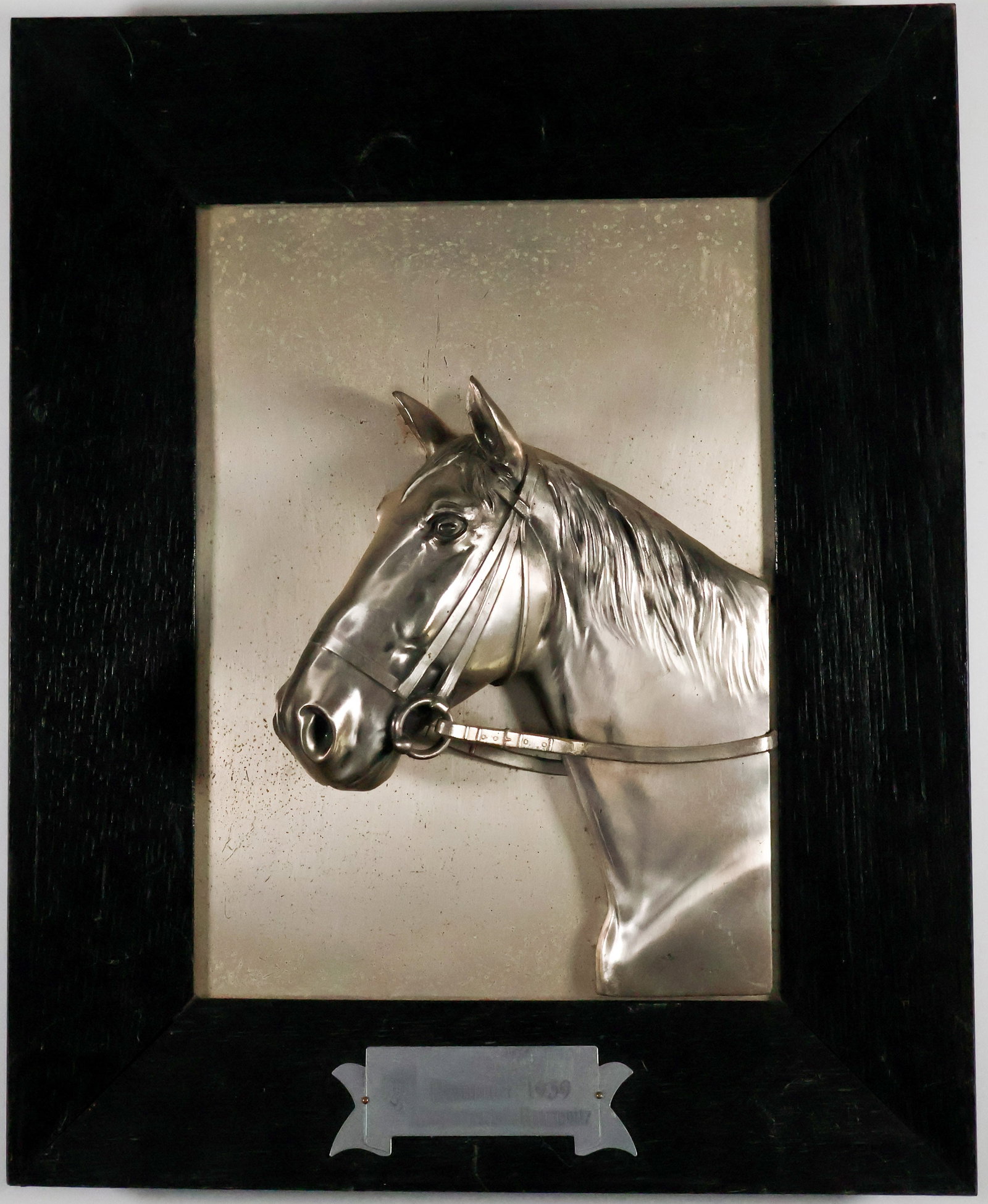 GERMAN CAVALRY SCHOOL RIDER’S AWARD: A German cavalry school award, 11.75 in. x 14.5 in., depicting a three-dimensional silver-plated reined horse looking to its left. The horse is set upon a black wooden frame along with a plaque in