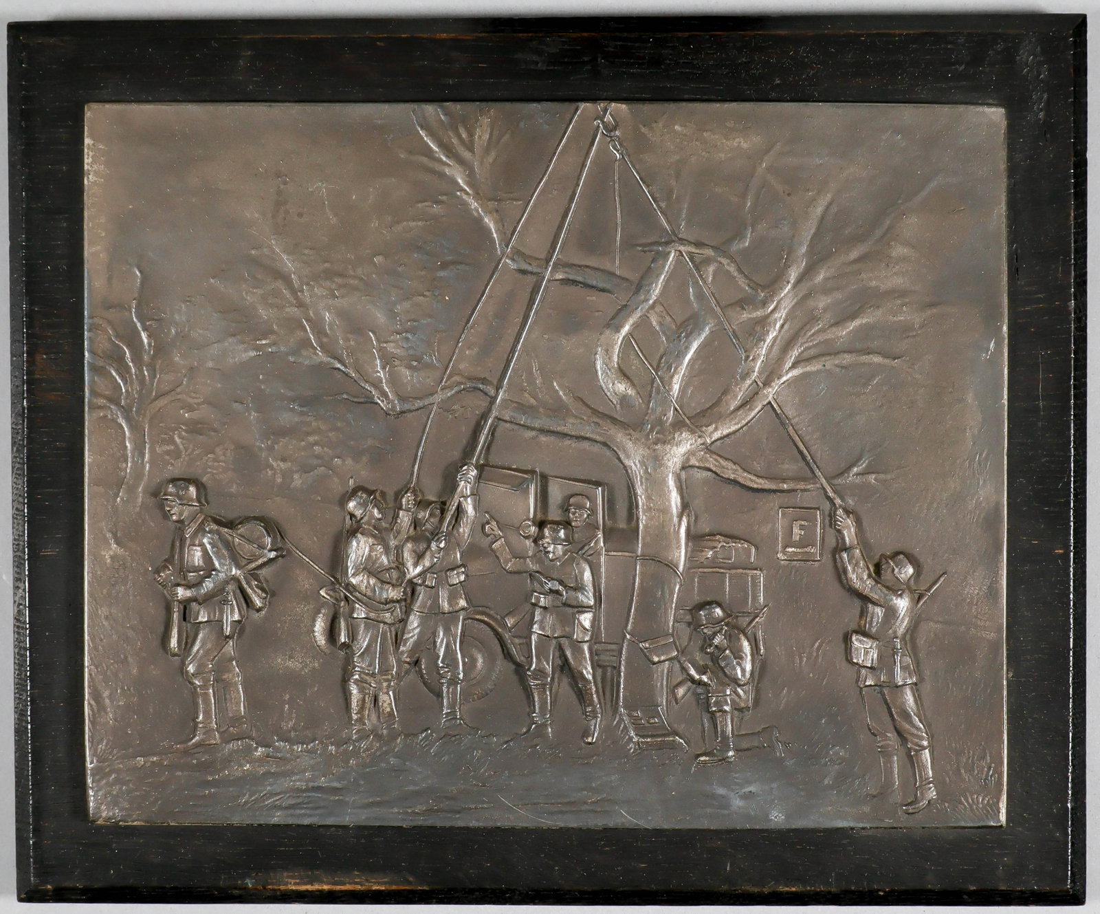 GERMAN WALL PLAQUE: Metal wall plaque, 8 x 6.5 in., depicting a team of seven men from a German Signal Corps installing communications, in relief. Mounted to a 9.5 x 8 in. wooden backing. Excellent detail, in fine condit