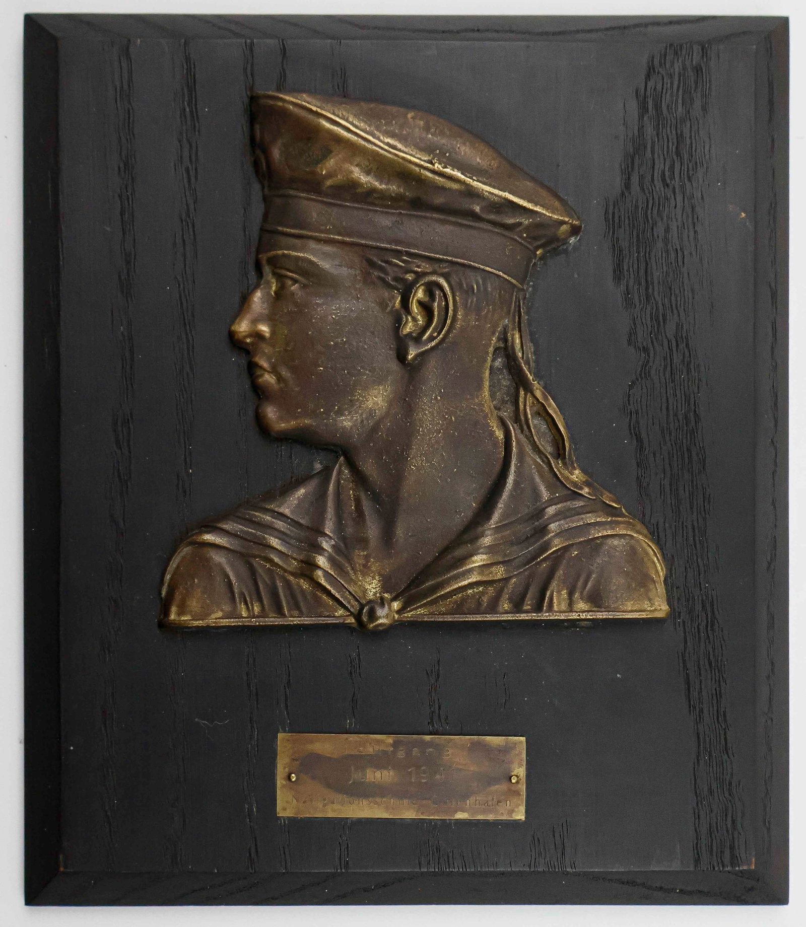 KRIEGSMARINE TRAINING PLAQUE: An award plaque, 7.5 in. x 9 in., given to those who successfully completed their training at a navigation school. In high relief is a portrait view of a German sailor, bronze construction. The plate