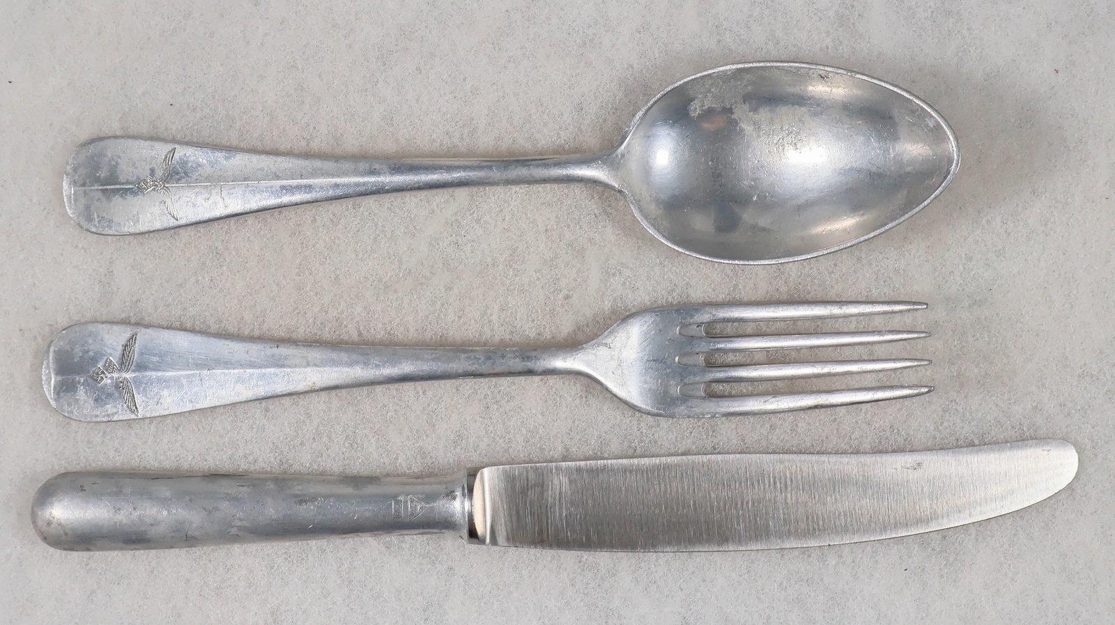 LUFTWAFFE TABLEWARE (3): Three pieces of standard Luftwaffe tableware, including aluminum fork, knife and spoon, the handles all bearing Luftwaffe emblem of an eagle with swastika. Good condition.