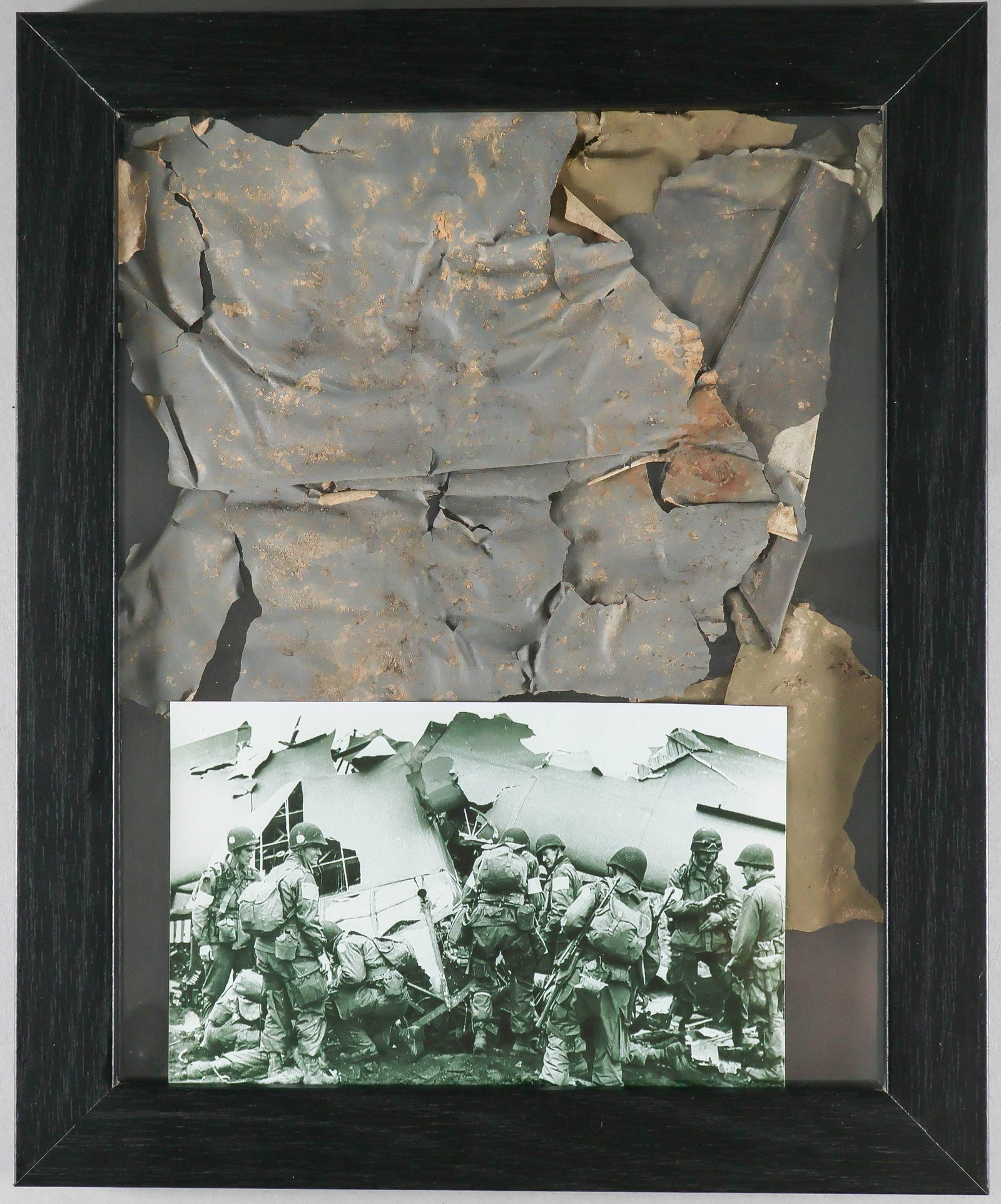 OPERATION MARKET GARDEN GLIDER FABRIC RELIC: A battered section of glider 'skin' as well as a swatch of parachute cloth, from a glider wrecked during the operation 'Market Garden'. Handsomely framed in a double glass black frame measuring about