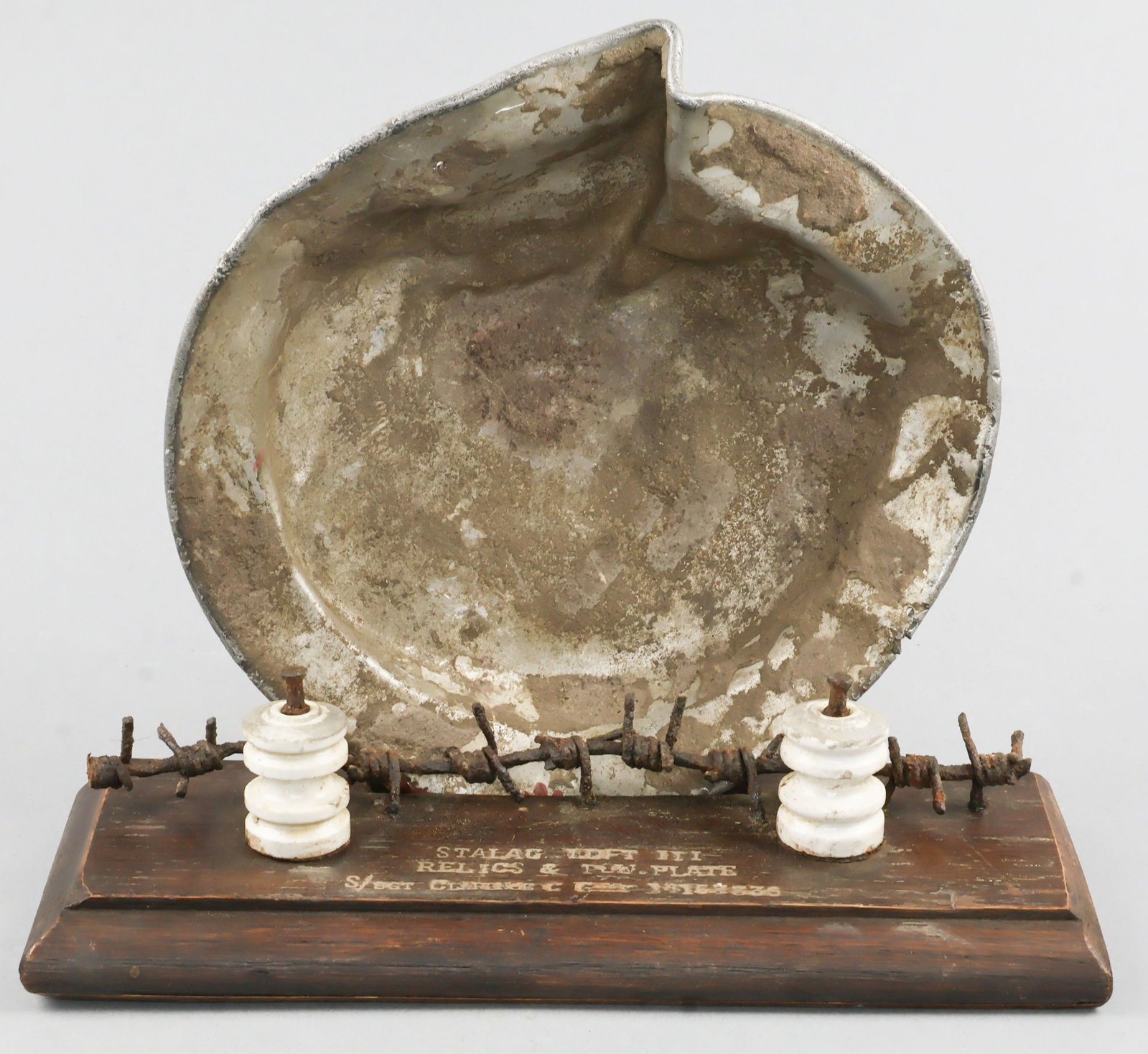 STALAG LUFT III RELICS FROM IDENTIFIED POW: Three relics of the notorious Stalag III prison camp from POW Clarence M. Gray, prisoner number 14153556 from Moultrie, GA. includes an 8.75 in. diameter metal plate with Gray’s name scratched