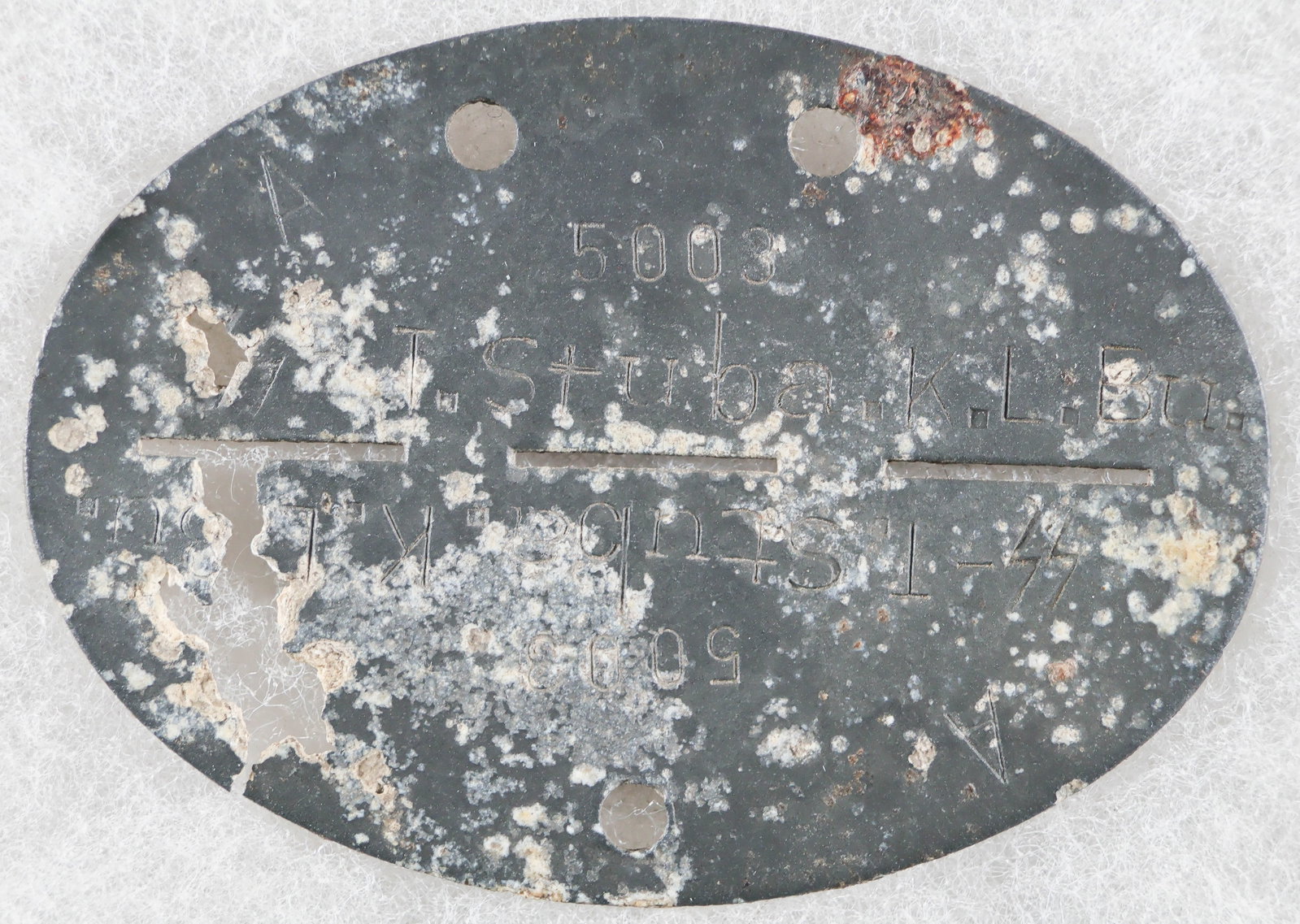 WAFFEN-SS DOGTAG FROM BUCHENWALD: Complete dog tag from a Waffen-SS soldier stationed at Buchenwald. This 'dug' tag reads 'Waffen-SS' on both halves of the tag on one side, and on the reverse both halves read: 'A 5003 SS-T. Stuba.