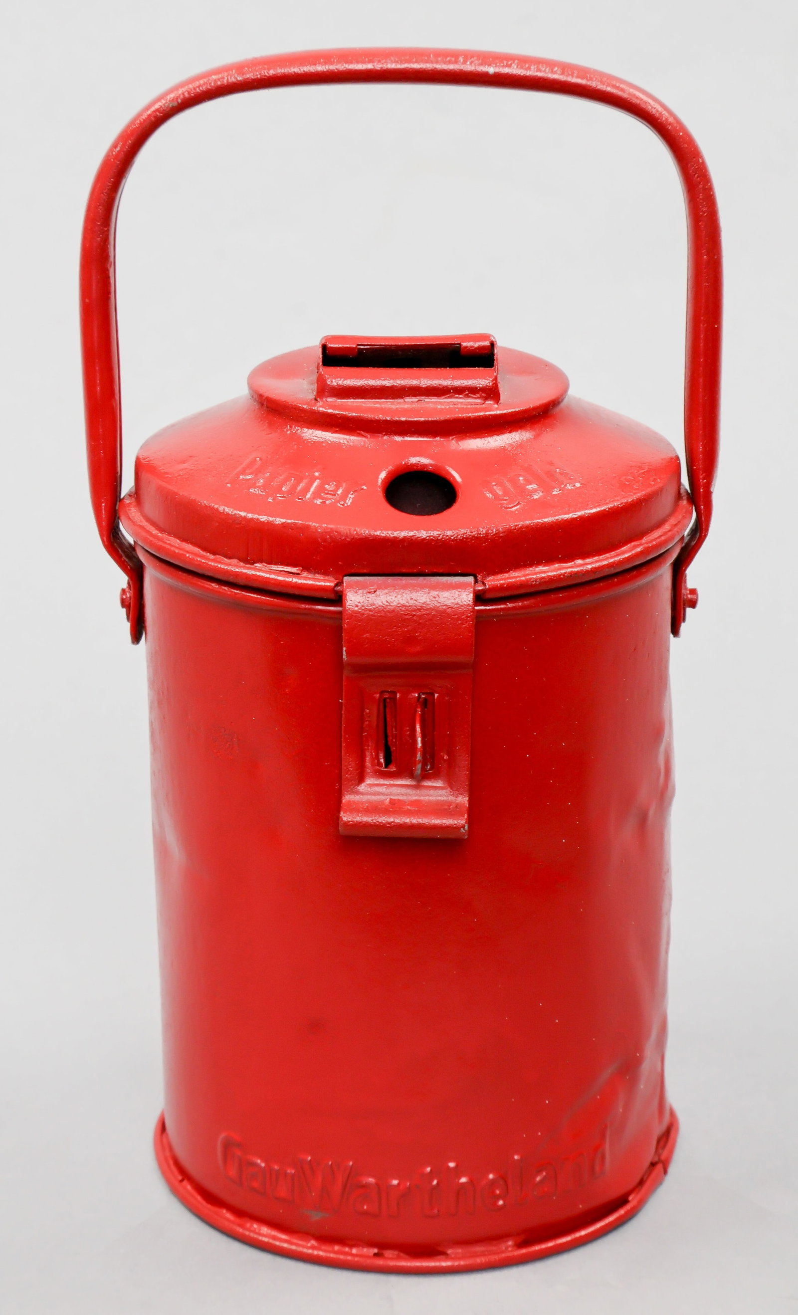 WINTERHILFSWERK COLLECTION CAN: Scarcer Gau-issued Winterhilfswerk collection can, red-painted steel, 7 in. tall and made by M. Westermann & Co., bearing lettering in relief at bottom: ‘Gau Wartheland’. Some dings but