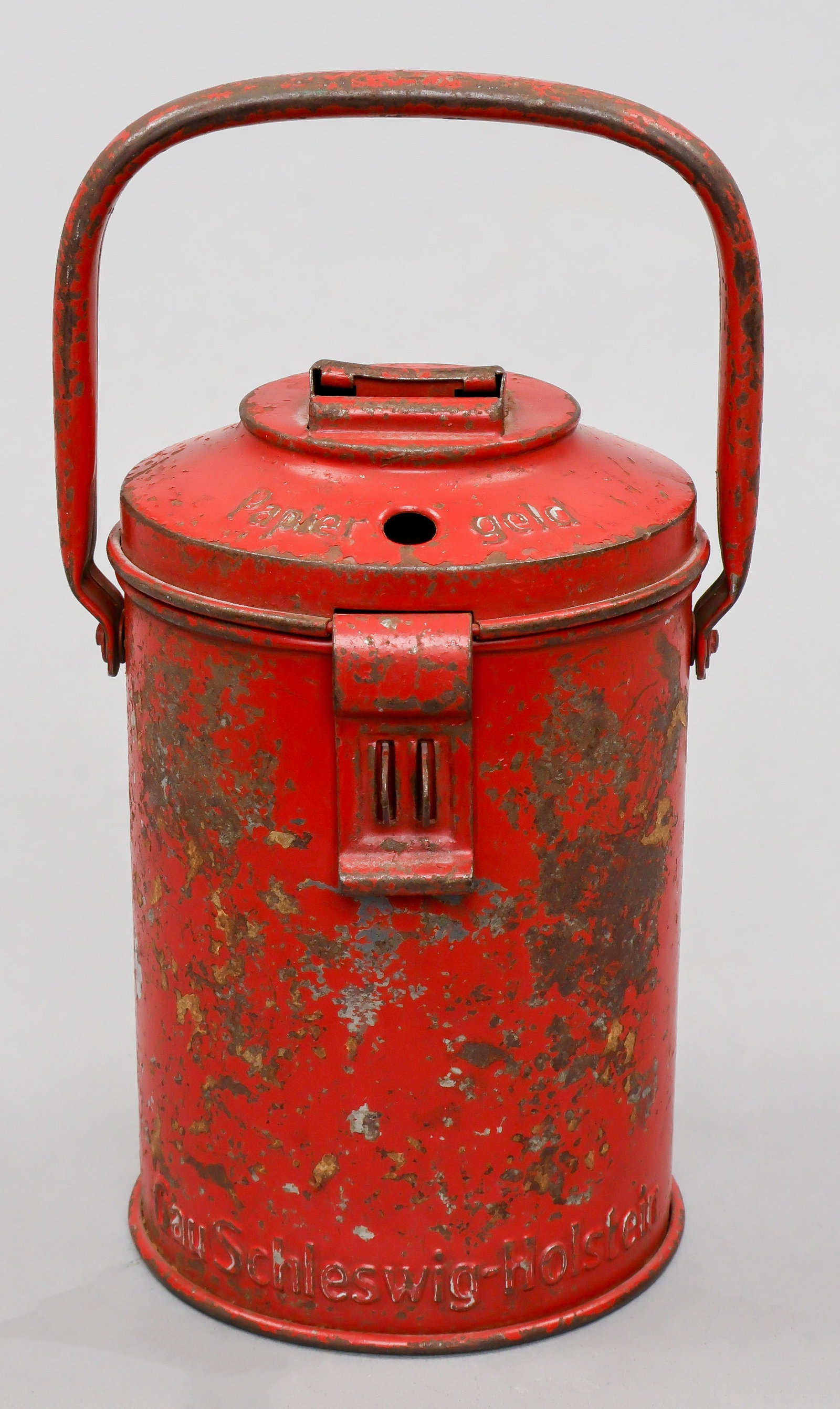 WINTERHILFSWERK COLLECTION CAN: Scarcer Gau-issued Winterhilfswerk collection can, red-painted steel, 7 in. tall, made by M. Westermann & Co., bearing lettering in relief at bottom: ‘Gau Schleswig-Holstein’. Loss to