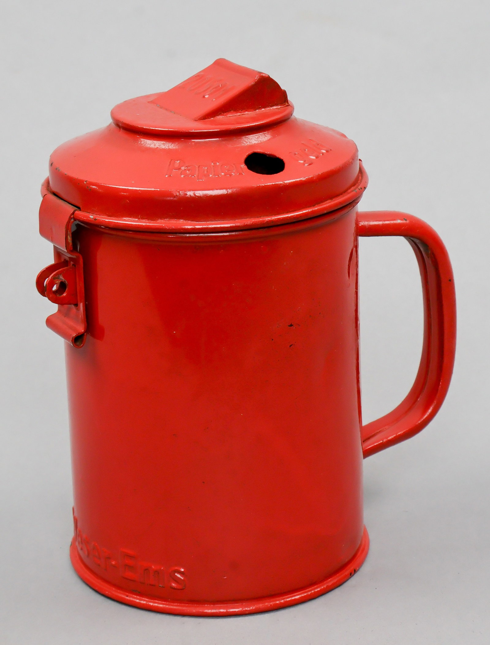 WINTERHILFSWERK COLLECTION CAN: Scarcer Gau-issued Winterhilfswerk collection can, red-painted steel 7 in. tall and made by M. Westermann & Co., bearing lettering in relief at bottom: ‘Gau Weser-Ems’. Paint intact, very