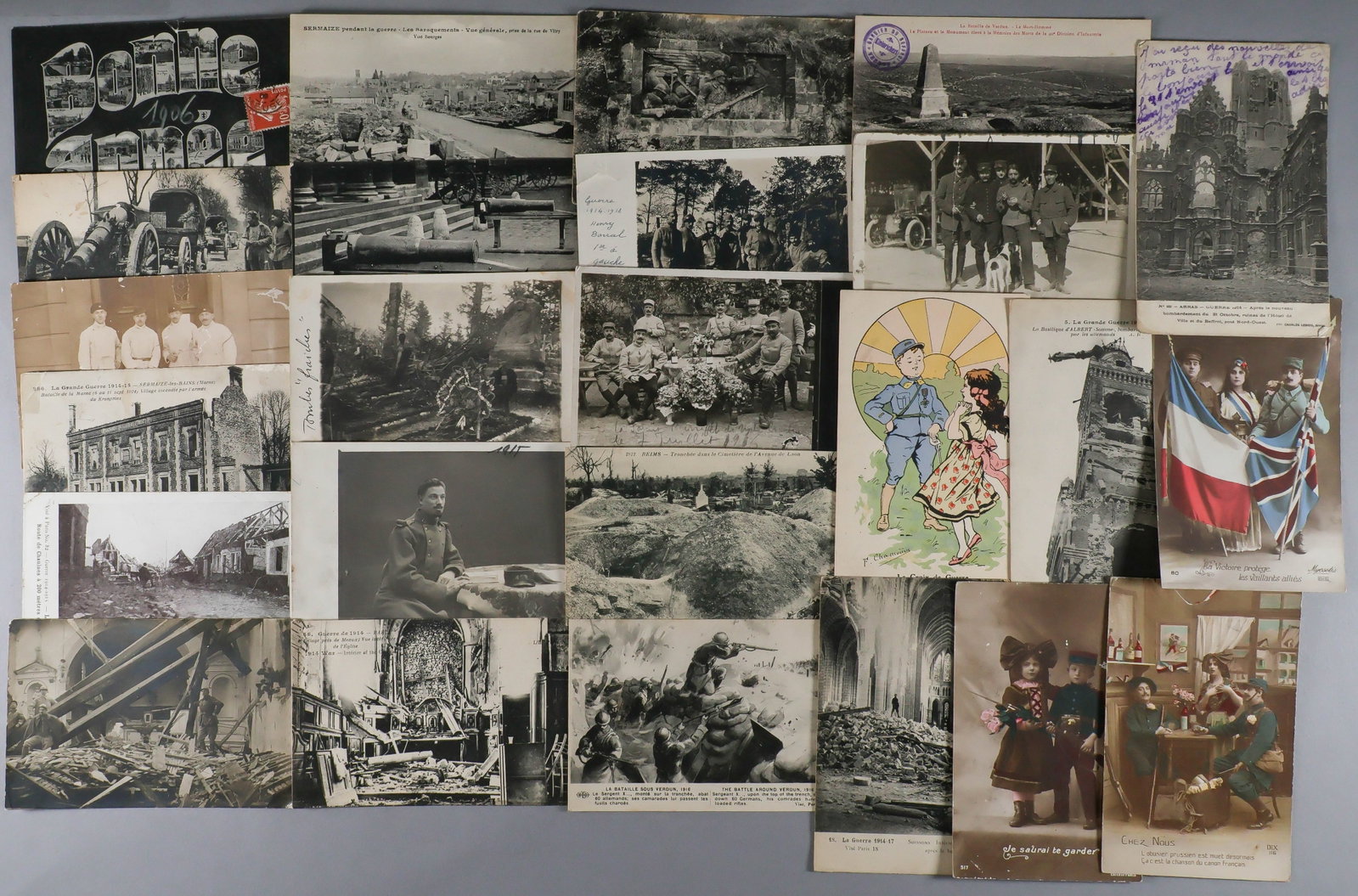 FRENCH WORLD WAR I POSTCARDS (24): A group of postcards with scenes from World War I, includes: the bombed-out town of Arras, a cannon making its way to the front in Verdun, the trenches of Reims, the interior of a bombed cathedral in 