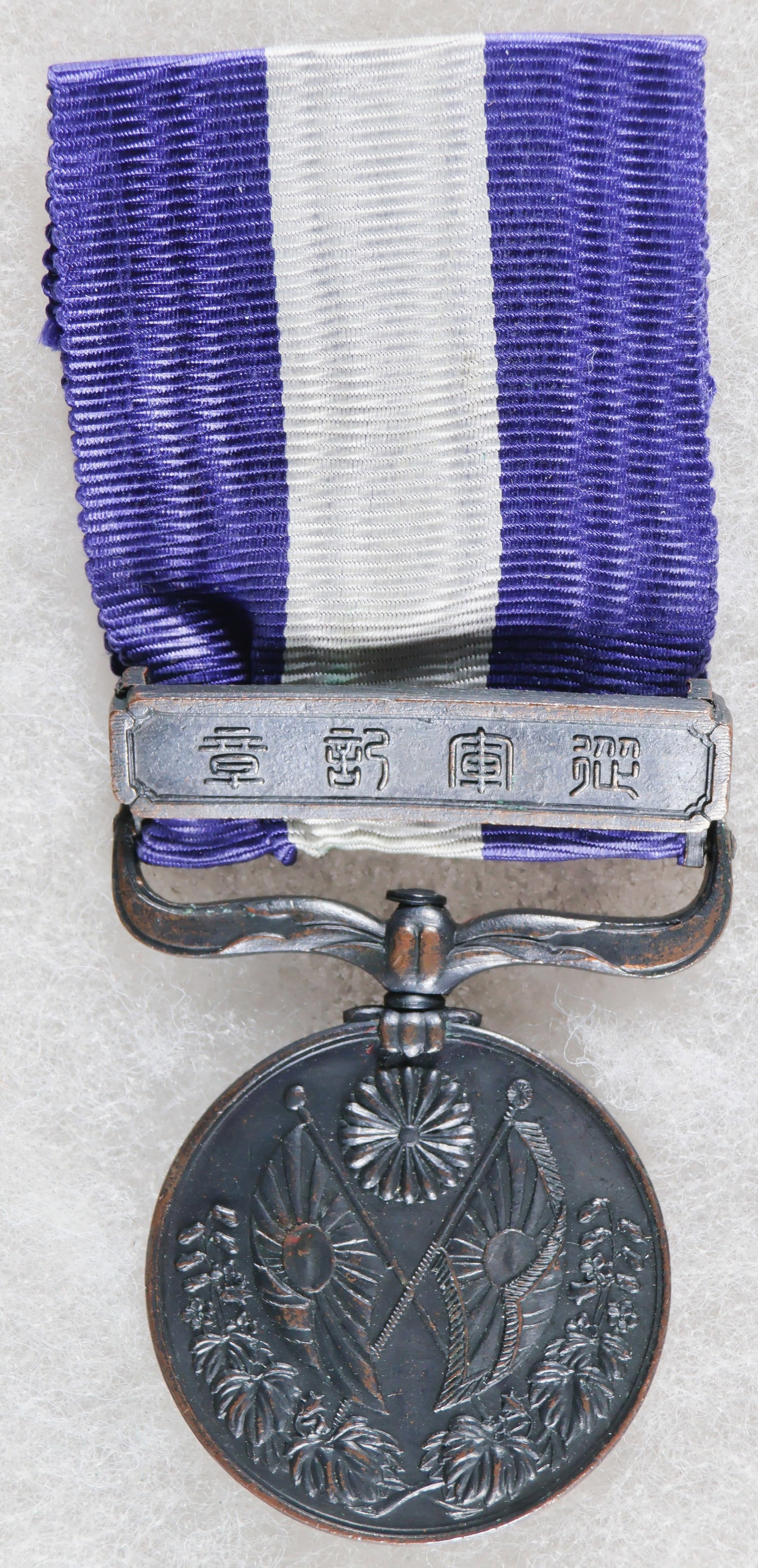 JAPANESE 1914-15 WORLD WAR MEDAL: An early-type Japanese War Medal 1914-15, approx. 1.15 in. dia., awarded to Imperial Japanese troops who participated in World War I. The medal, constructed of black-finished bronze, depicts crossed I