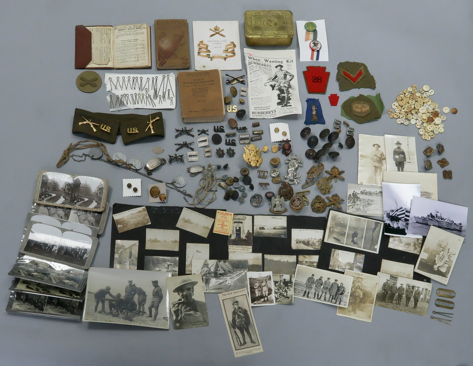 WORLD WAR I INSIGNIA, PHOTOGRAPHS AND EPHEMERA: A large, interesting box lot containing numerous pieces related to American and British soldiers during World War I, includes: approx. 56 original b/w photographs, including three album pages containi