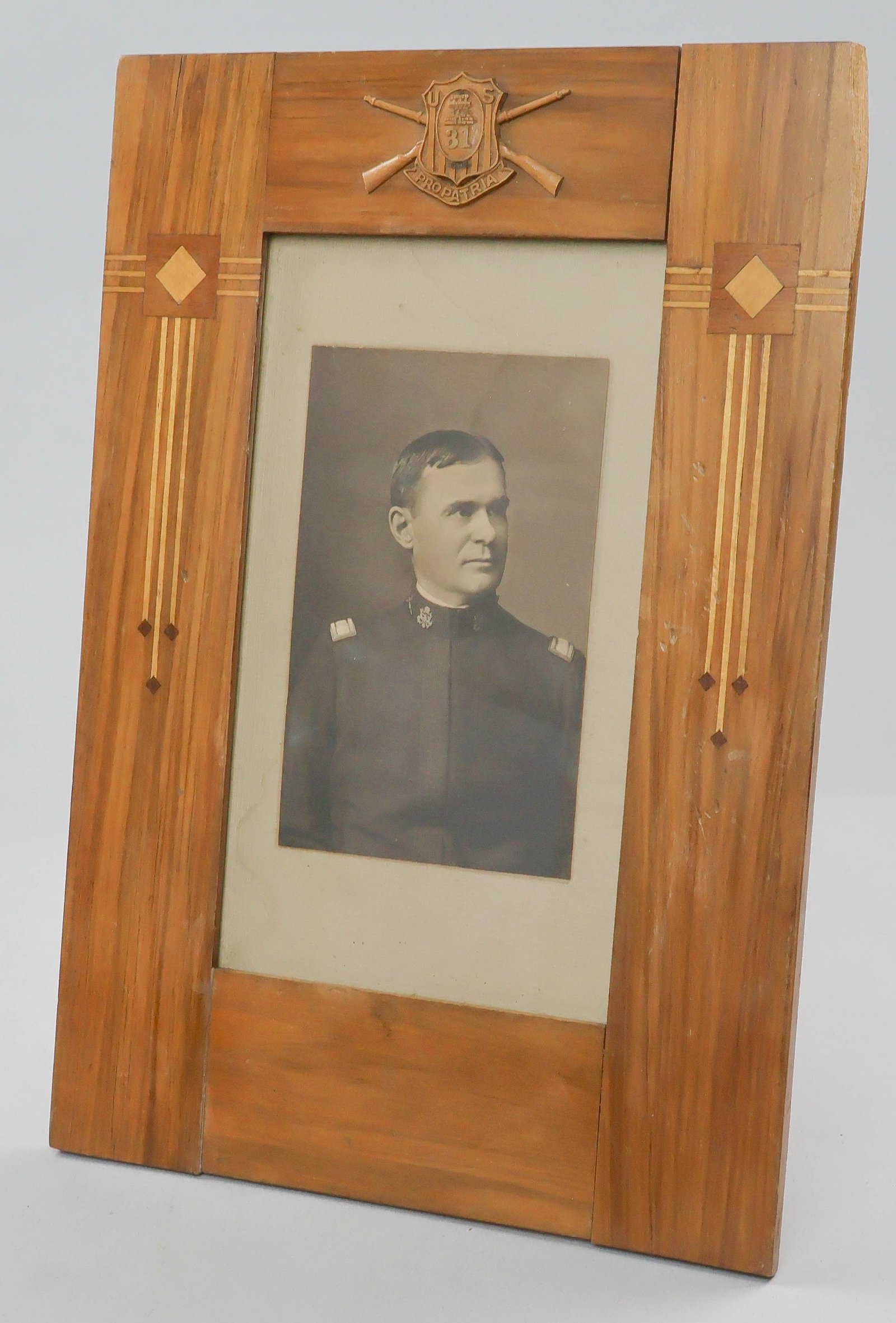 31ST INFANTRY REGIMENT CUSTOM FRAME WITH PHOTOGRAPH: Rare, wonderful wood frame with photograph, both referencing the famous U.S. 31st Infantry 'Polar Bears'. The frame is a work of art, incorporating a finely cut wood emblem at top depicting a shield,