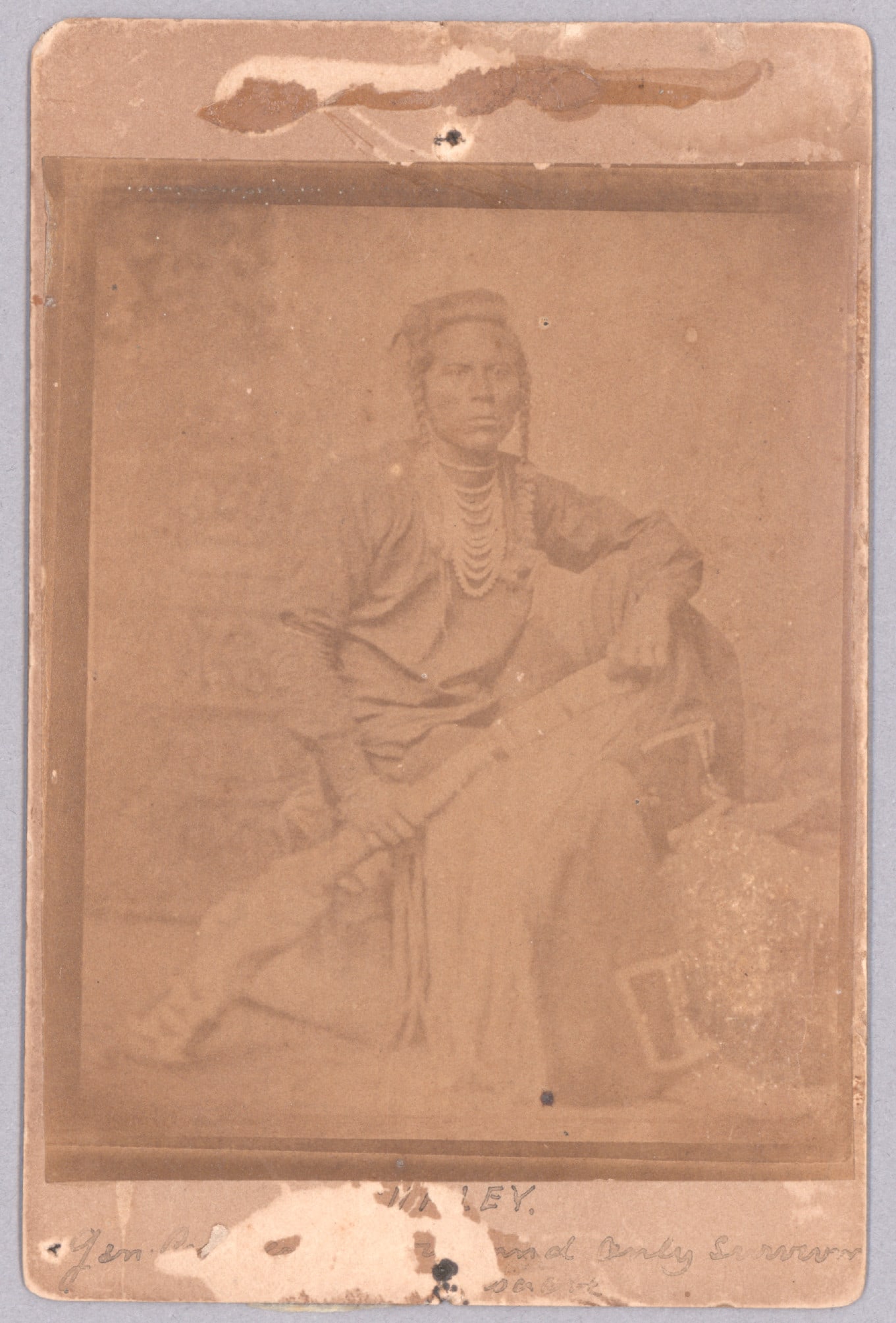 (LITTLE BIG HORN): A rare cabinet card showing Bull Half White, also known as Curly, one of George Custer’s Crow scouts, in a seated pose in native dress. A note on verso reads: ‘Curley [sic] Gen.