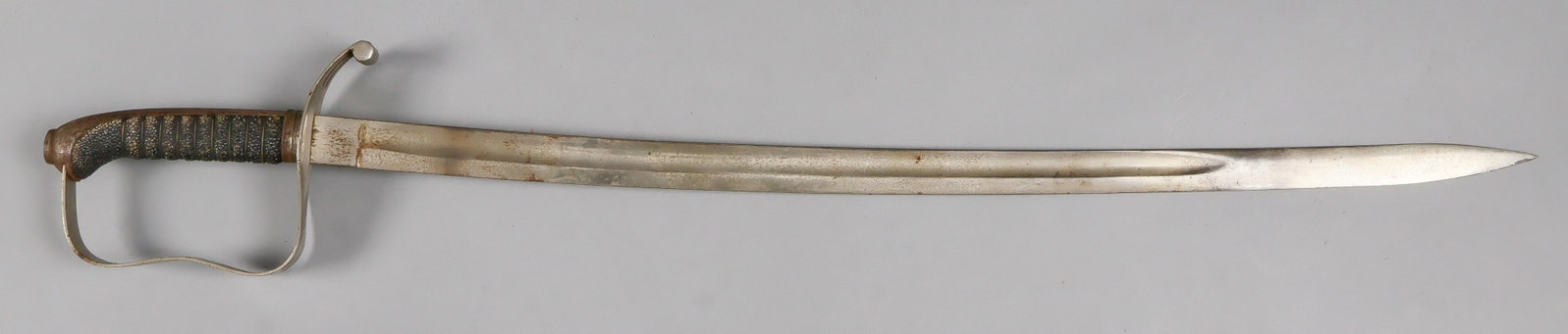 PARADE SABER: Unmarked, early-mid 20th century parade or dress saber, 28 in. blade, 33.5 in overall, with plain, slightly curved blade, steel handquard and sharkskin-wrapped grip. Shows freckling to the blade and h