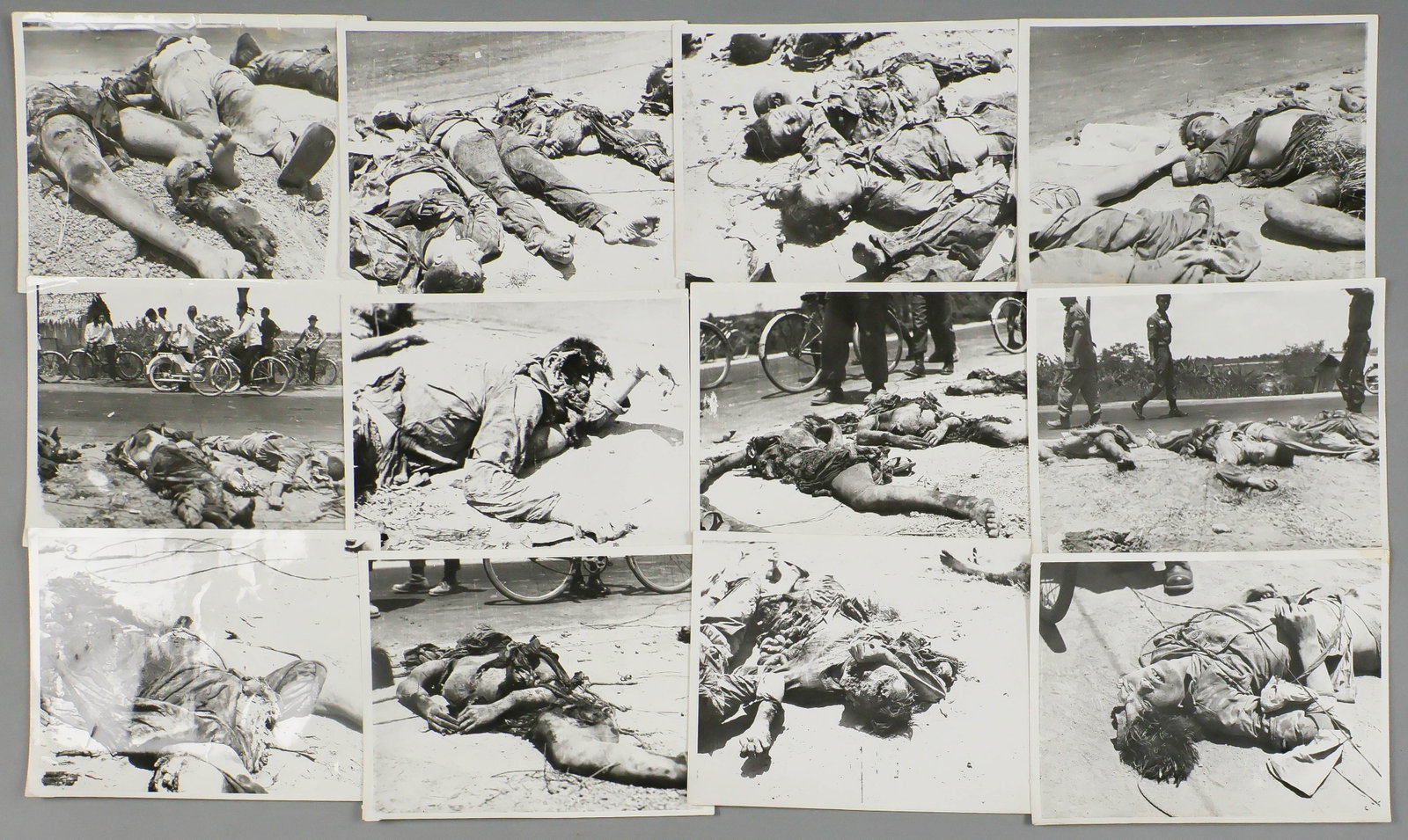 VIETNAM WAR CIVILIAN CASUALTIES ORIGINAL PHOTOGRAPHS (12): A group of twelve gruesome original first-generation 8 x 10 in. b/w photographs, all depicting groups of dead civilians, including women and children, along a roadside. A paper tag included with the