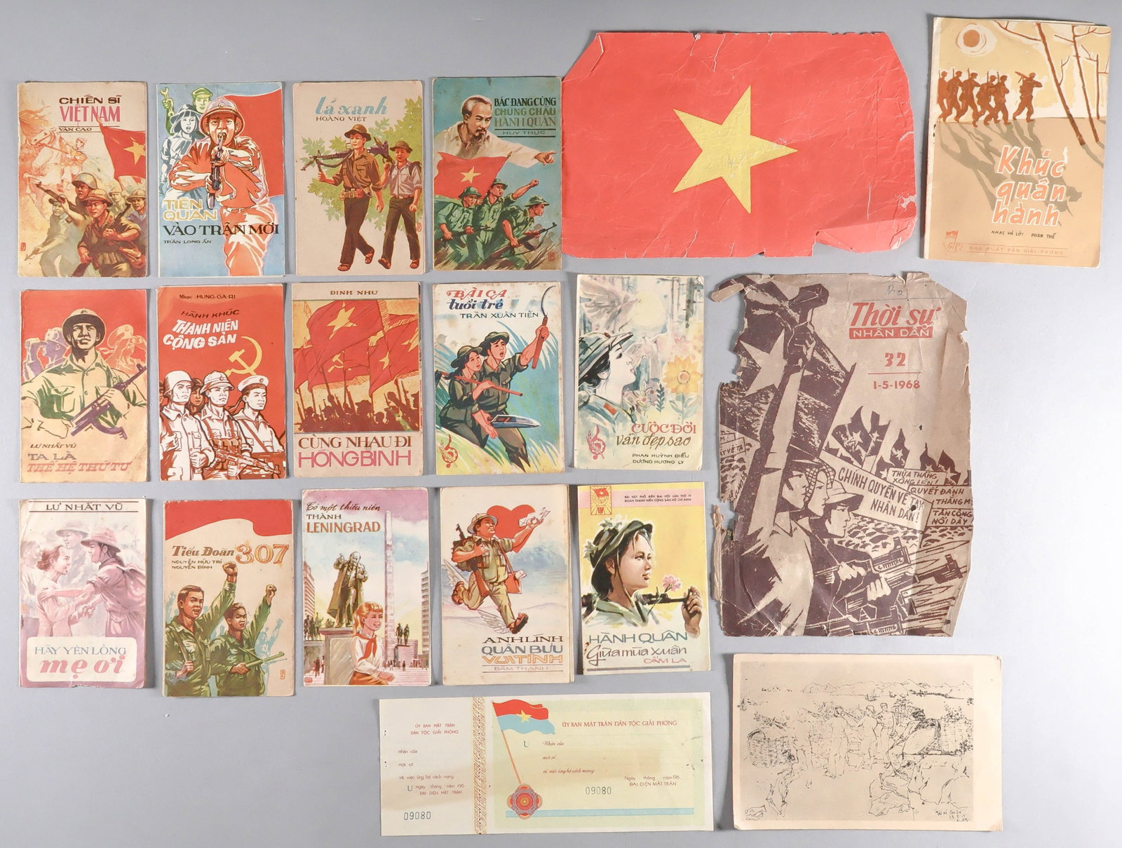 VIETNAM WAR PROPAGANDA (19): A group of interesting ephemera: 15 tiny colorful patriotic song books, a postcard depicting ‘Militiamen of Cat Ba Island’, a well-worn propaganda leaflet 7 x 5 in. published on May Day
