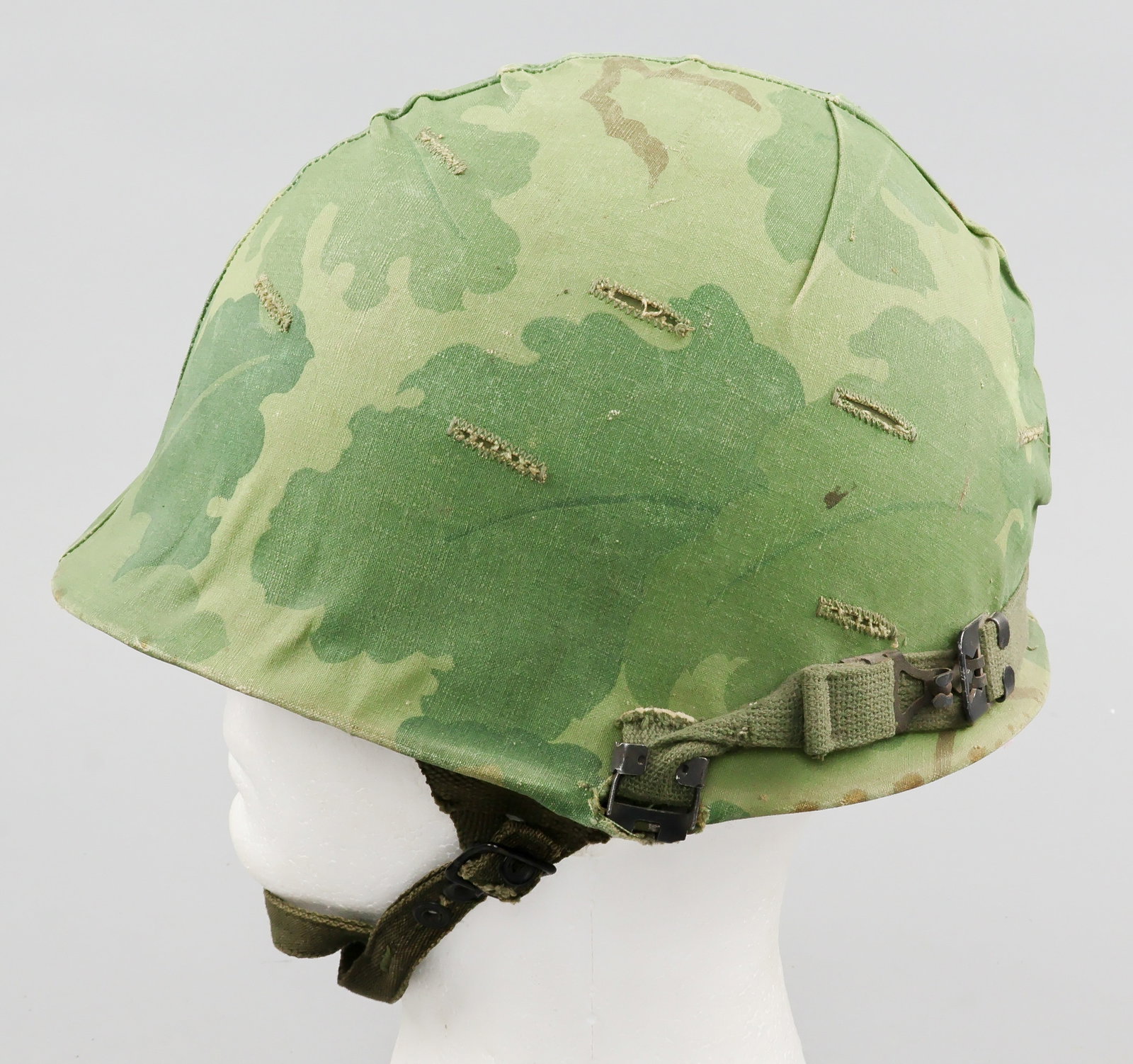 VIETNAM WAR U.S. M1C HELMET: A fine example of a Vietnam War-era U.S. M1C combat helmet, the exterior finished olive-green with a sand texture and the interior in flat olive-green, with the heat-stamped batch number ‘M 324