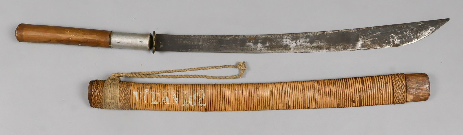 BURMESE DHA: A Burmese-style ‘dha’, a long knife or sword with a curved blade commonly used across Southeast Asia. This example features a hand-forged 21 in. blade, 30.5 in. overall, with a small cross