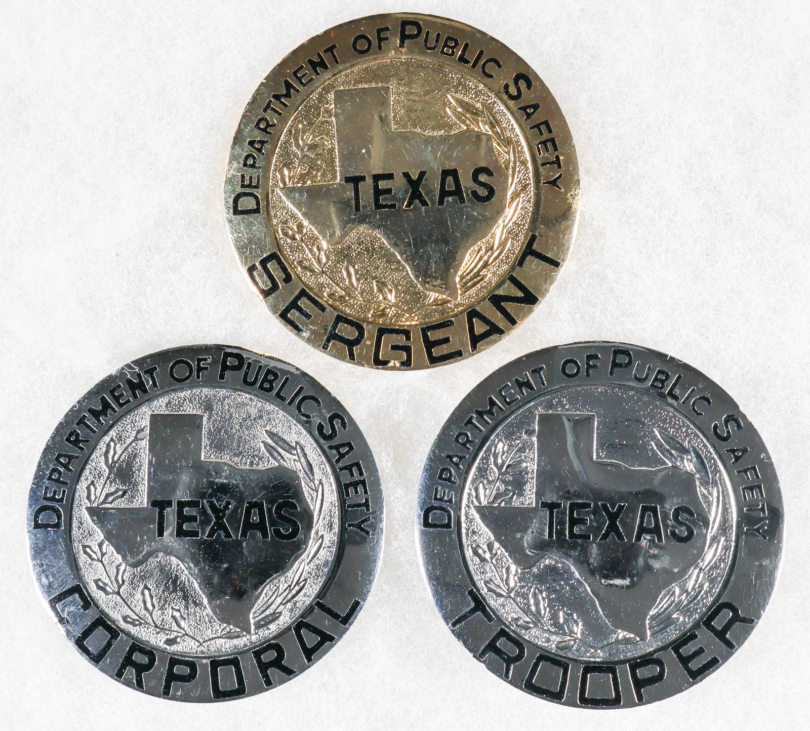 TEXAS DEPARTMENT OF PUBLIC SAFETY BADGES BY BLACKINTON (3): Good lot of three vintage Texas Department of Public Safety officers’ badges, each approx. 2 in. dia., for the ranks of Sergeant (in gold finish), Corporal and Trooper (both in silver finish).