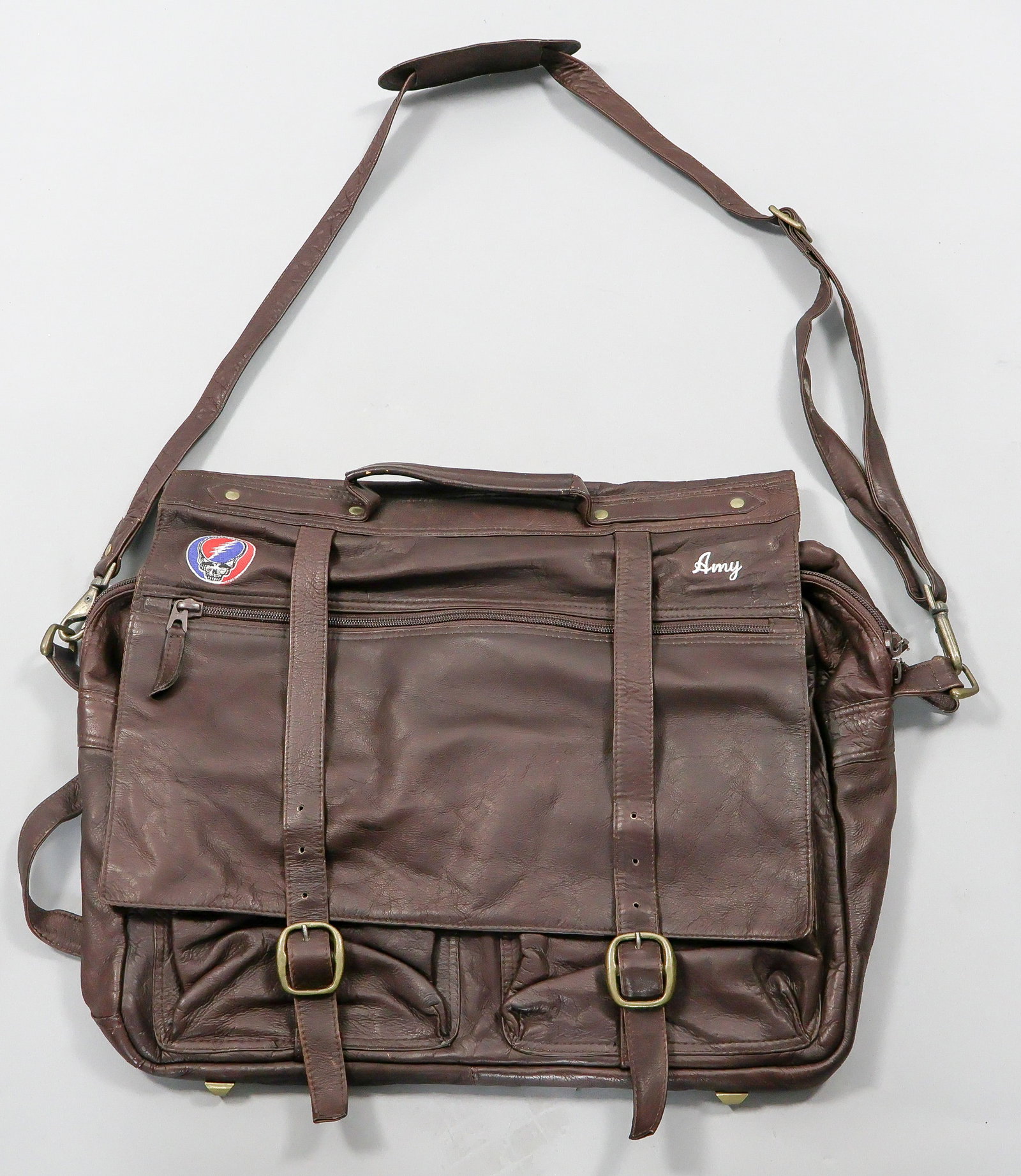 GRATEFUL DEAD CREW-ISSUE LEATHER BRIEFCASE: Rare ca. early 1990s leather briefcase issued by the Grateful Dead only to touring road crew members and perhaps other very close associates. This brown supple leather accessory measures approx. 18 x