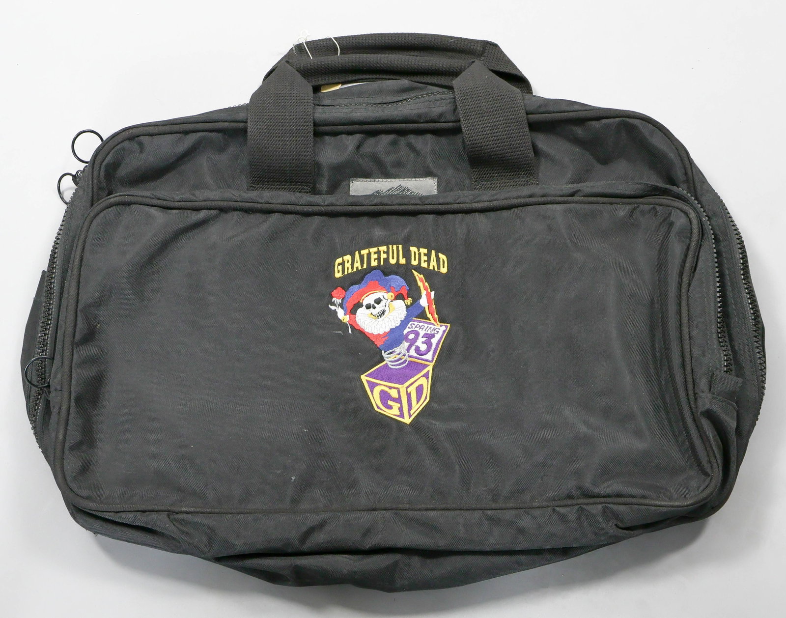 GRATEFUL DEAD CREW-ISSUE NYLON BRIEFCASE: Rare 1993 nylon zippered briefcase issued by the Grateful Dead only to touring road crew members and perhaps other very close associates. The black heavy duty case features a large central zippered