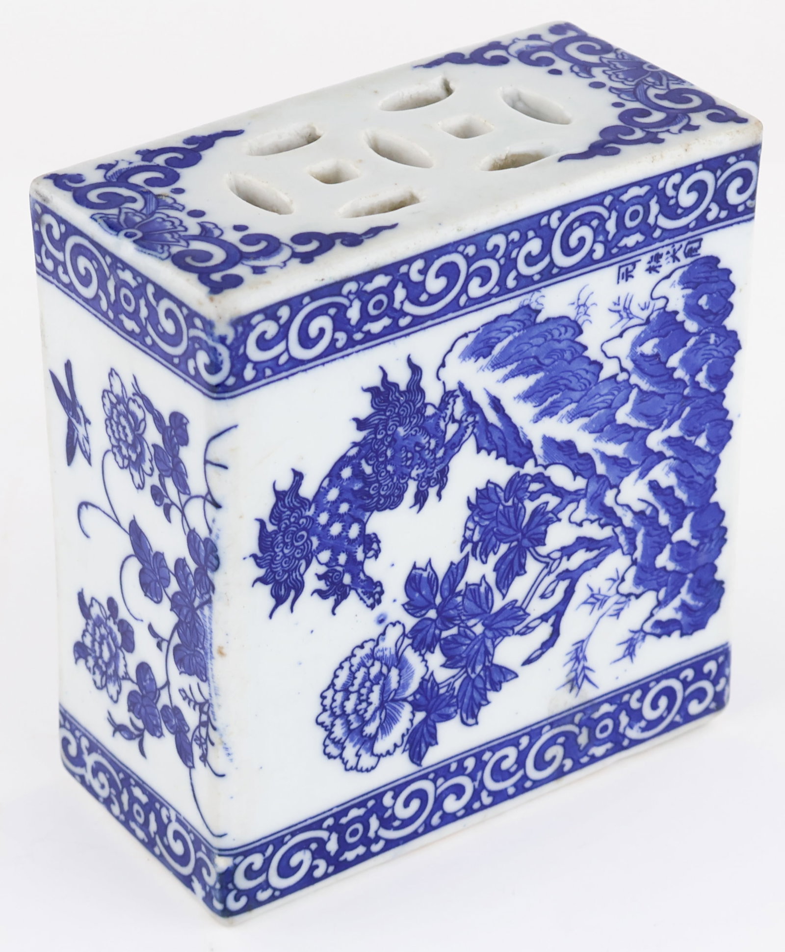 ANTIQUE CHINESE OPIUM PILLOW: Antique Chinese opium smoker’s pillow, 5.5 x 5 x 2.5 in. blue fired paint on white porcelain, unmarked. This very solid and sturdy example bears images of peonies, birds, trees, etc. and is in