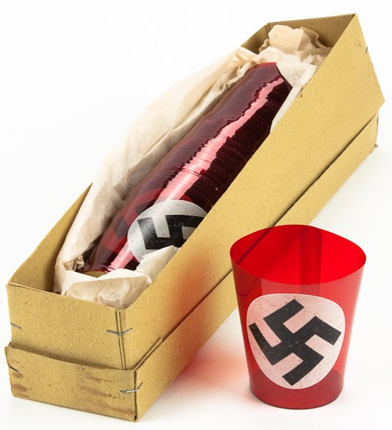 NAZI FUNERAL CANDLE HOLDERS: NAZI FUNERAL CANDLE HOLDERS Lot of approx. 100 thin red celluloid candle holders with cardboard bottoms, each about 3 1/2" tall. The front surface has a painted white round field with black mobile swa