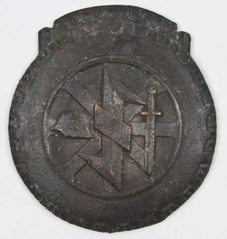 NEDERLAND DIVISION LOYALTY BADGE: NEDERLAND DIVISION LOYALTY BADGE Uncommon brass badge honoring the "Nederland Division", Dutch soldiers recruited to fight under the SS, 47mm. wide, bearing the division seal, a German helmet and a sw