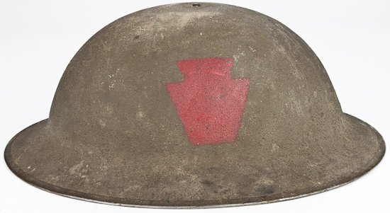 28TH DIVISION HELMET: 28TH DIVISION HELMET World War I soldier's helmet bearing red "keystone" indicative of the 28th Infantry Division painted on left side, green khaki "sand" paint with rubberized leather and leather lin
