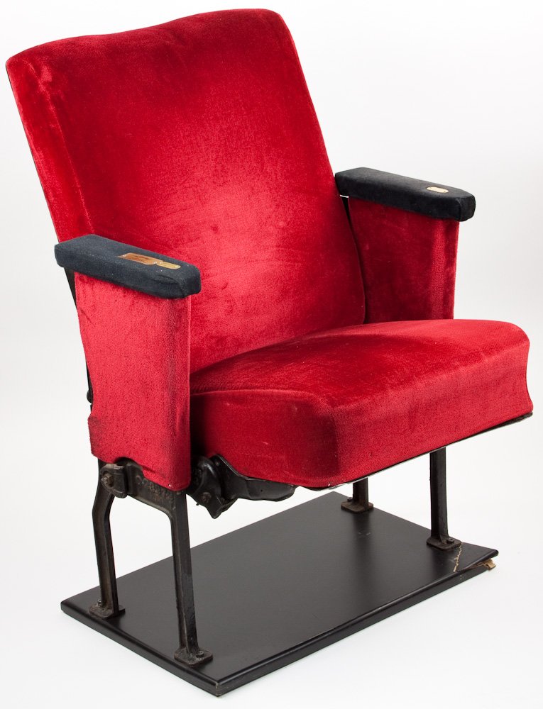 RADIO CITY MUSIC HALL CHAIR: RADIO CITY MUSIC HALL CHAIR Radio City Music Hall chair. A well-padded folding red satin orchestra seat removed from New York's famous Radio City Music Hall during its restoration. Small chip to parti