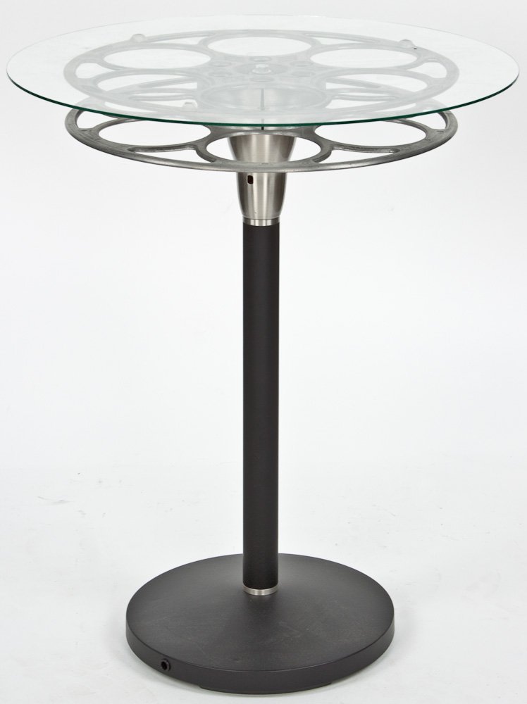 FRANK LLOYD WRIGHT FILM REEL TABLE: FRANK LLOYD WRIGHT FILM REEL TABLE Glass table supported by a film reel once owned by Frank Lloyd Wright, with provenance indicating that the reel was used by Wright at his Hillside Theater at Taliesi