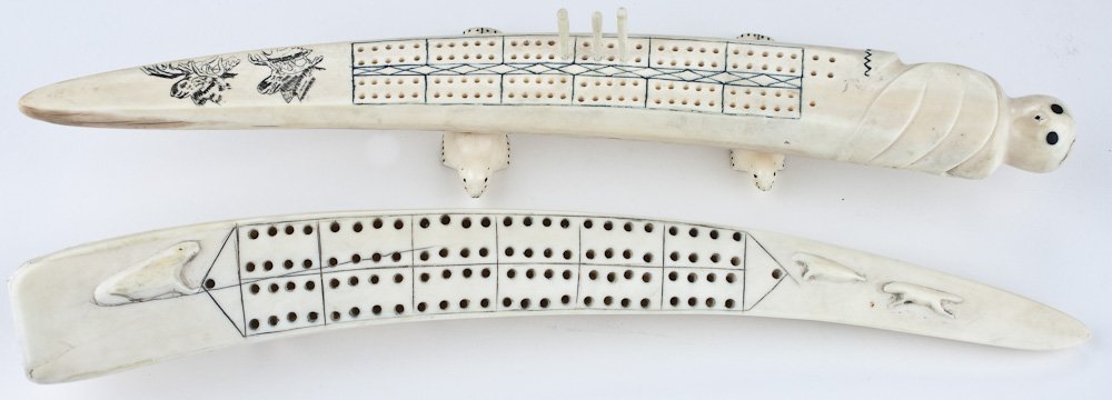 WALRUS TUSK CRIBBAGE BOARDS: WALRUS TUSK CRIBBAGE BOARDS Pair of walrus tusk cribbage boards carved by Inuit artists, both ca. 1950s, the first 15 1/2" long bearing the head of a snow eagle at the wider end, with two carved moose