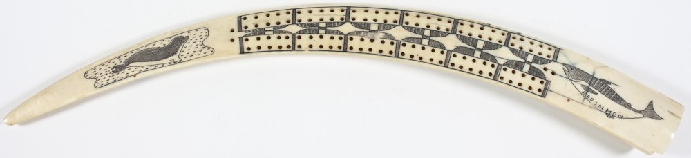 INUIT-CARVED WALRUS TUSK CRIBBAGE BOARD: INUIT-CARVED WALRUS TUSK CRIBBAGE BOARD Cribbage board carved from a walrus tusk by an Inuit artist, 18" long, ca. 1940s, attractive carvings include a seal on an ice floe and a "Red salmon", and on t