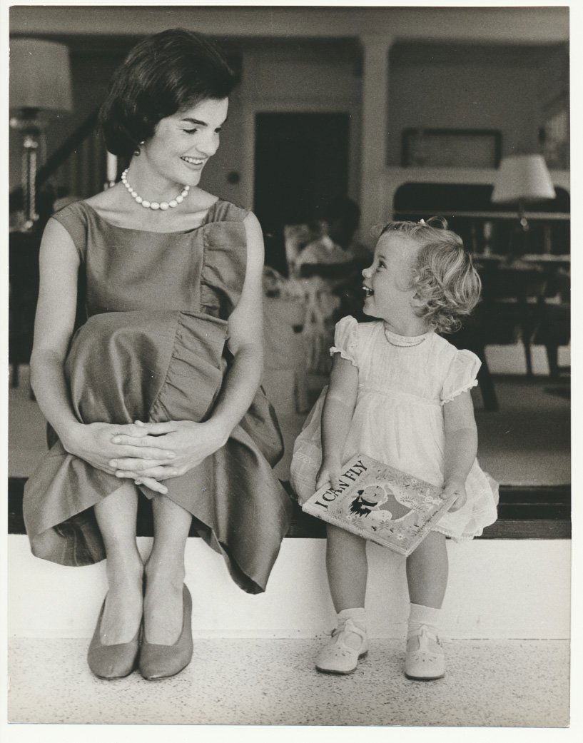 (JACQUELINE KENNEDY): (JACQUELINE KENNEDY) (1929 - 1994) First Lady and wife of John F. Kennedy, 35th President of the United States. Contemporary photo, 7 3/4" x 10" b/w, an image of the First Lady seated with Caroline by