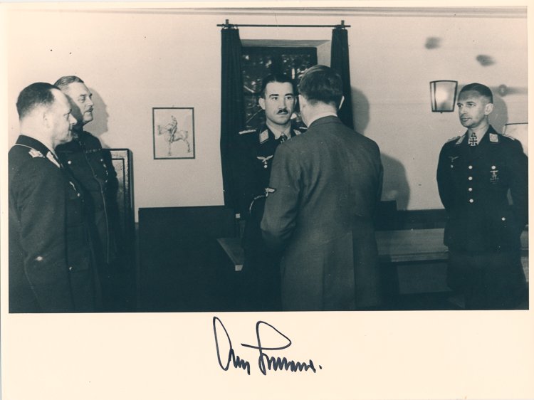 ADOLF GALLAND: ADOLF GALLAND (1911 - 1994) German fighter ace of World War II and general of fighters. Fine S.P. 9 1/4" x 7" b/w, shows Galland receiving an award from Adolf Hitler (back to camera), boldly signed in