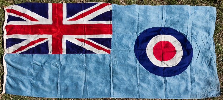 DOUGLAS BADER'S R.A.F. TANGMERE SQUADRON FLAG: DOUGLAS BADER'S R.A.F. TANGMERE SQUADRON FLAG A heavy cotton R.A.F. squadron flag, ca. 1939-41, 103" x 42" with printed turquoise blue field, RAF roundel and Union Jack canton. A hemp rope and wood do