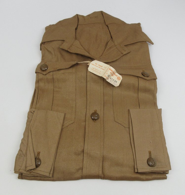 HITLER YOUTH MEMBER'S SHIRT WITH TAGS: HITLER YOUTH MEMBER'S SHIRT WITH TAGSLong-sleeved cotton twill Hitler youth shirt in unissued condition. Chest pockets and buttons sleeves with HJ buttons, with original RZM paper tags attached.