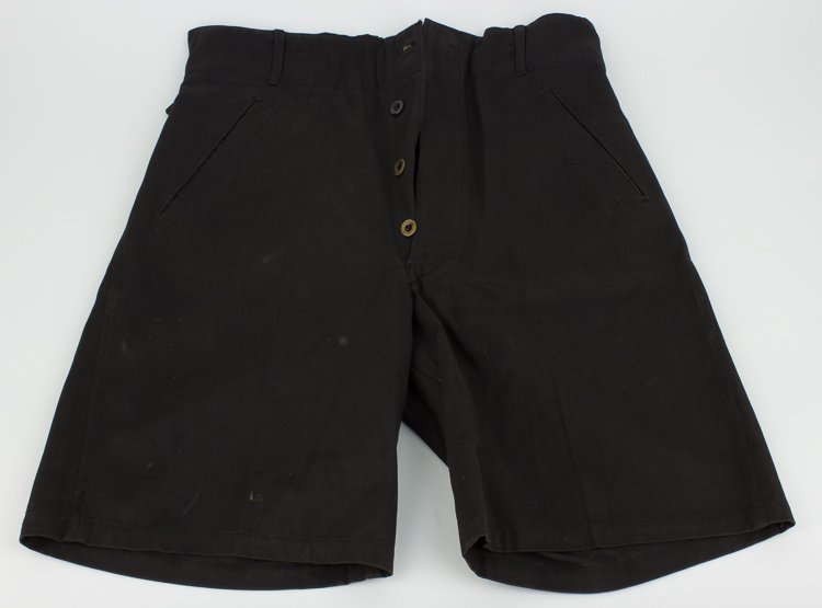 HITLER YOUTH SHORTS: HITLER YOUTH SHORTS Pair of black cotton shorts, 20 1/2" x 15 1/2" at the waist, with two slash hip pockets and two flap-covered seat pockets. The fly is secured by three polished wood buttons, and a 