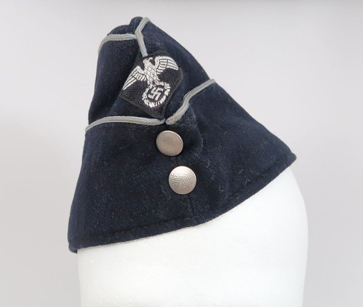 DEUTSCHES ARBEITSFRONT GARRISON CAP: DEUTSCHES ARBEITSFRONT GARRISON CAPDAF officer's garrison cap in fine condition. Machine-sewn flatwire eagle, silver officer's piping, and two silver pebbled buttons affixed at front. Leather sweatban