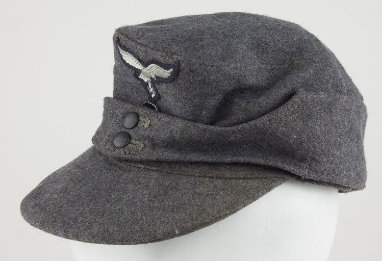LUFTWAFFE ENLISTED MAN'S M43 FIELD CAP: LUFTWAFFE ENLISTED MAN'S M43 FIELD CAP Luftwaffe enlisted man's M43 field cap of blue-gray wool with separate hand-sewn national eagle and ockade insignia. The two side panels meet at the front where