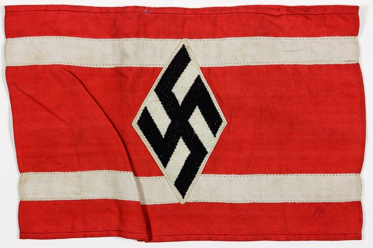 NSDSTB ARMBAND: NSDSTB ARMBAND Red cotton armband, 7 1/2" x 5", with two applied white bands, and an embroidered diamond-shape mobile swastika. These armbands were worn by members of the national Socialist German Stu