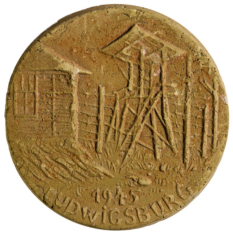 ART FROM A U.S. ARMY PRISON FOR NAZI ADMINISTRATORS: ART FROM A U.S. ARMY PRISON FOR NAZI ADMINISTRATORS Unusual, crudely-cast ceramic medallion, 4" wide x 1/2" thick, an image in bas relief of a prison camp showing a guard tower, barracks, and barbed w