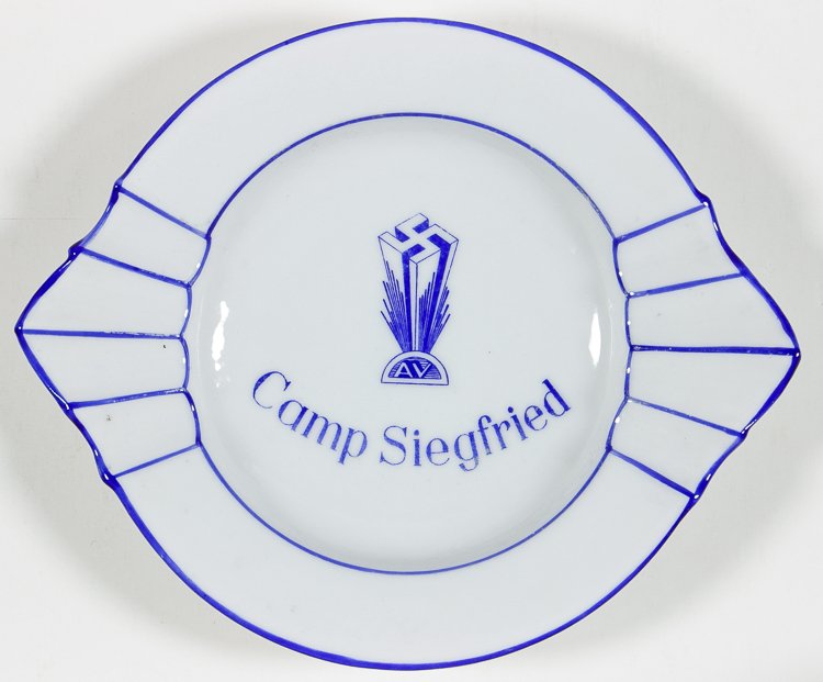GERMAN-AMERICAN BUND "CAMP SIEGFRIED" ASHTRAY: GERMAN-AMERICAN BUND "CAMP SIEGFRIED" ASHTRAY Ashtray bearing the Nazi insignia and name of "Camp Siegfried", 6" wide white porcelain, with hallmark of German china maker J. L. Menau. Fine. Camp Siegf