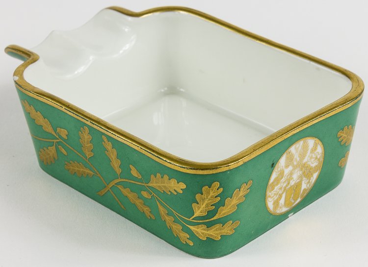 HERMANN GORING 50TH BIRTHDAY CIGAR ASHTRAY: HERMANN GORING 50TH BIRTHDAY CIGAR ASHTRAY A birthday present given by Hermann Goring on the occasion of his fiftieth birthday, a porcelain cigar ashtray with gold acorns and oak leaves on a green bac