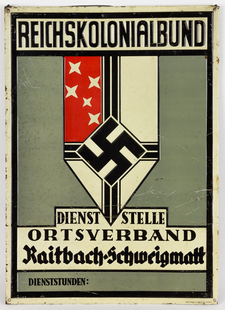 REICHSKOLONIALBUND SIGN: REICHSKOLONIALBUND SIGN Enameled metal sign, 17 1/2" x 12 1/2", depicting the insignia of the "Reichskolonialbund" ('Reich Colonial League"), a vertical white pennant divided by intersecting black ban