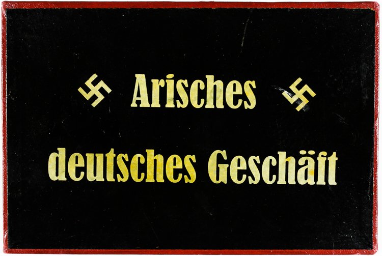 "ARYAN GERMAN BUSINESS" SIGN: "ARYAN GERMAN BUSINESS" SIGN Black cardboard sign with a red border, 4 3/4" x 7", with white text reading: "Arisches deutsches Geschaft" ("Aryan German Business"), flanked on each side by a mobile swa