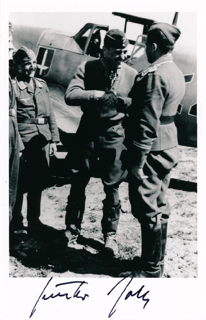 GUNTHER RALL: GUNTHER RALL (1918-2009) German fighter pilot and third highest-scoring ace of all time, with 275 "kills". S.P., 3 3/4" x 6" b/w, showing a smiling Rall shaking hands with another Luftwaffe officer in