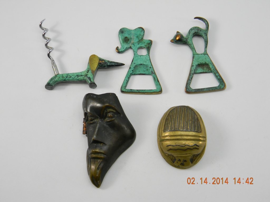 Lot of Bronze Face, Brass Scarab, Corkscrew Opener: Two brass bottle openers, one cat design and one elephant design. One brass scarab paper weight. One brass dog cork screw. One bronze decorative mask clip.