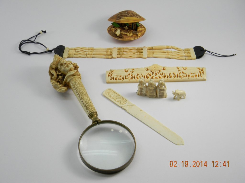 Assorted Lot of Asian Items: Lot includes magnifying glass with figure of mans head on handle, one beaded bracelet, carved figure of three women, one elephant, one clam with house inside, and a purse top clip and letter opener.
