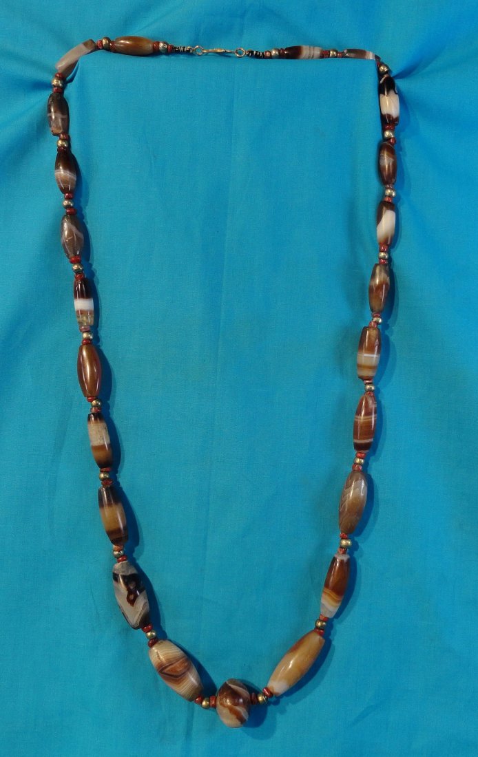 Chinese Antique Agate and Carnelian Bead Necklace: Very attractive necklace strung with 22 elongated old, agate beads, 1 rounded oval agate bead,alternating with small Carnelian beads sandwiching silver beads. Antique or antique style gold catch. Some