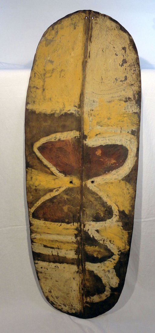 Antique Mendi War Shield Papua New Guinea: Attractively painted antique carved Papua New Guinea war shield or Worrumbi, probably from the Mendi Valley. The shield is painted with warm natural pigments and features a moth like figure on the fro
