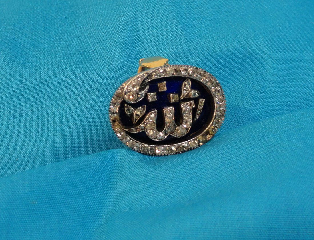 Islamic Gold and Enamel Ring with Diamonds Allah: Gold ring with Arabic praise for Allah done in silver or white gold set with diamonds on an enameled dark blue background. Height 1 Inch (2.5 cm) Width 1 Inch (2.5 cm)